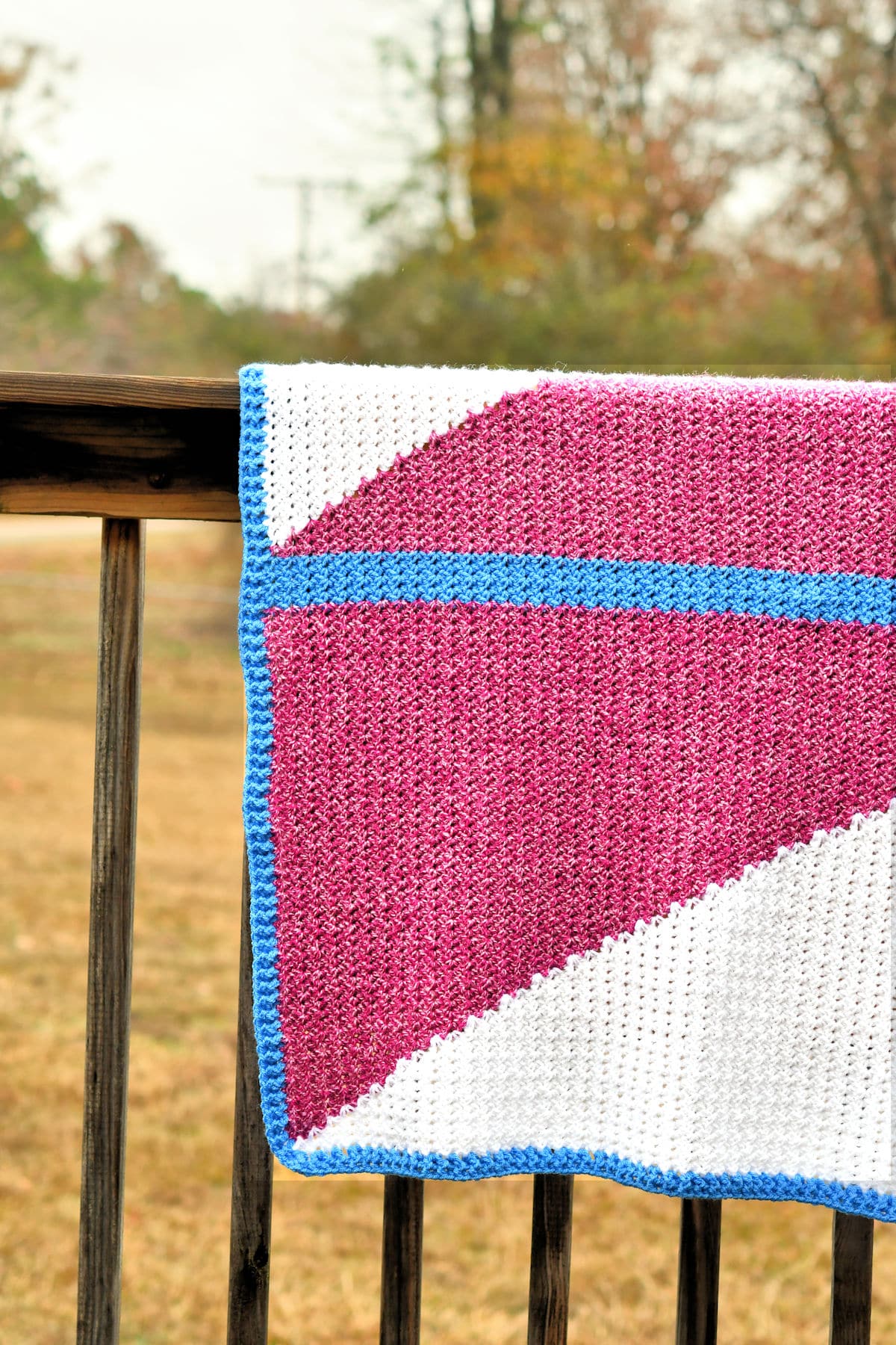 Modern Crochet Baby Blanket displayed outdoors on a railing
