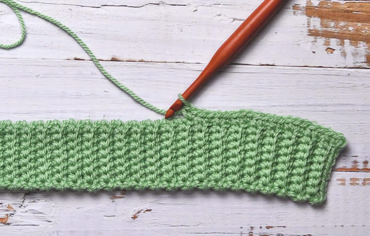 Closeup of crocheting on long edge of single crochet ribbing