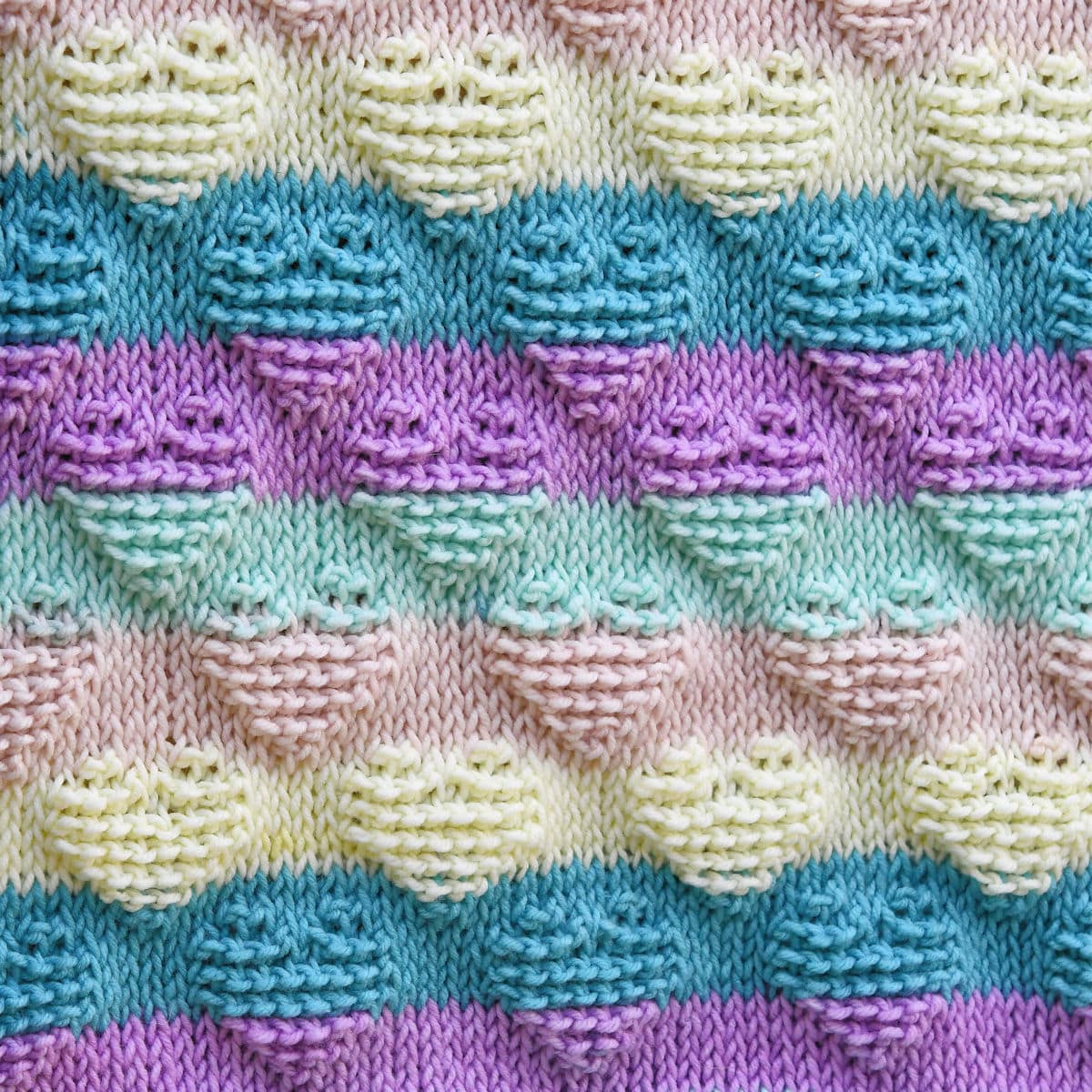 close up showing heart motif stitch pattern of Striped Hearts Baby Afghan