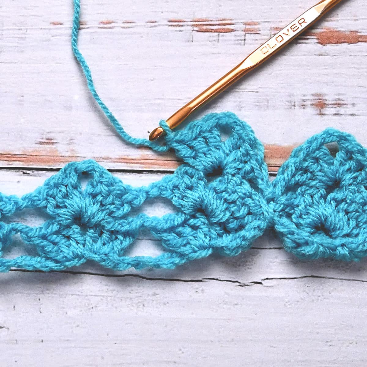 closeup of crochet working around three chain spaces