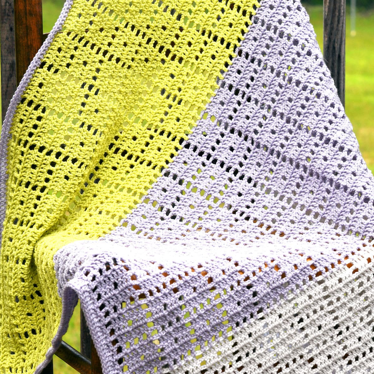 filet crochet baby afghan draped over a chair