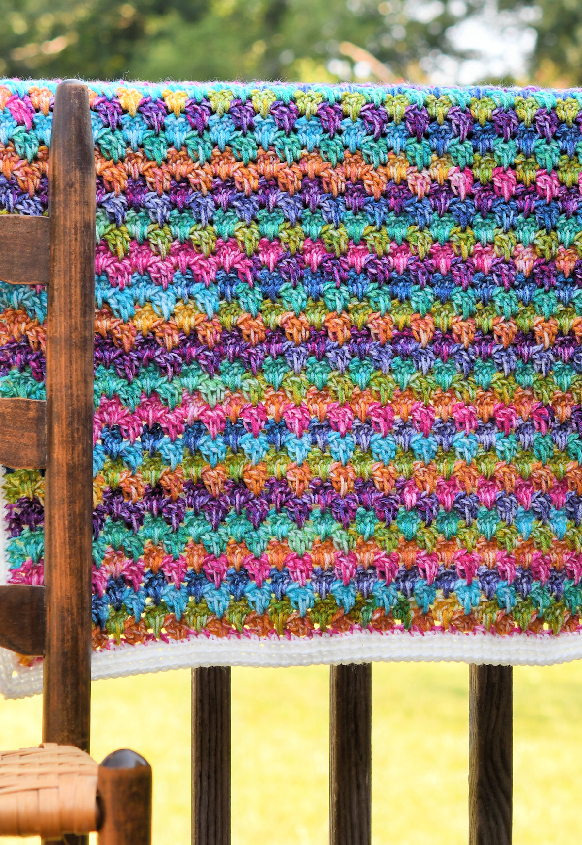 Easy crochet baby blanket made with colorful self-striping yarn.