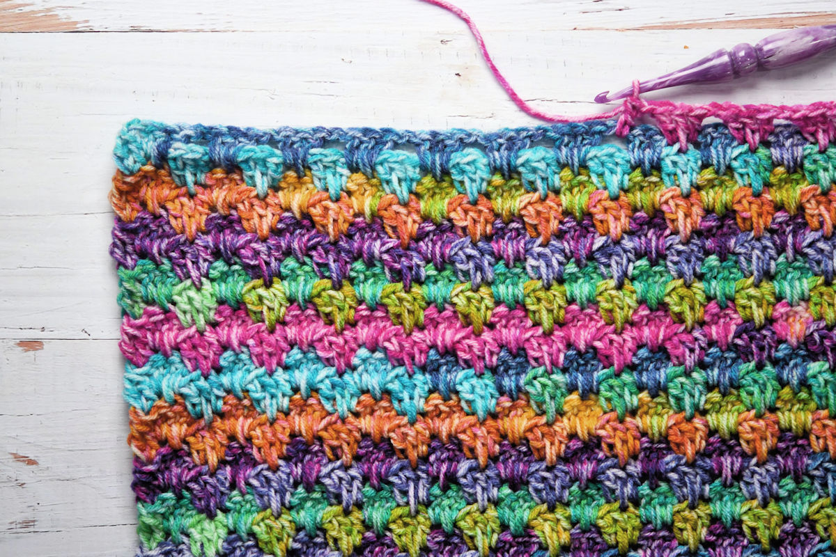 Detailed view of colorful crochet stitch pattern for baby blanket.